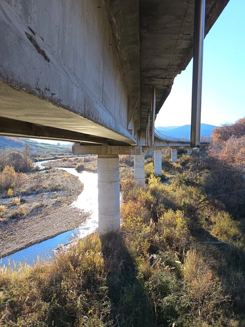 Intradosso di un viadotto su un fiume, ripreso da sotto l'impalcato